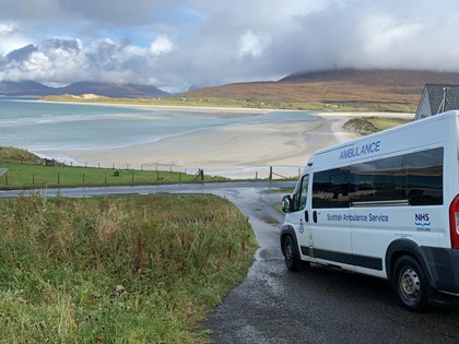 A Scheduled Care Ambulance next to a beach
