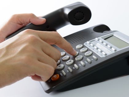 Somebody dialling a number on a landline phone