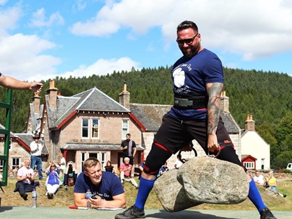 Calum lifting heavy stones at strongman competition