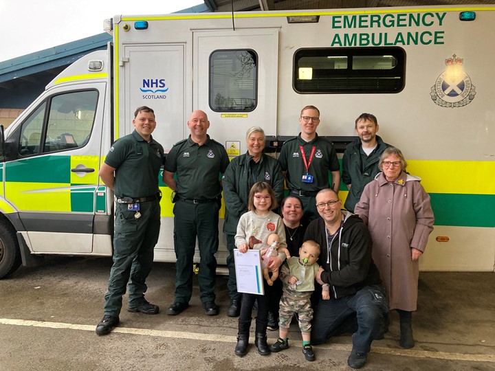 Alice with family and certificate at Paisley station with other ambulance service staff