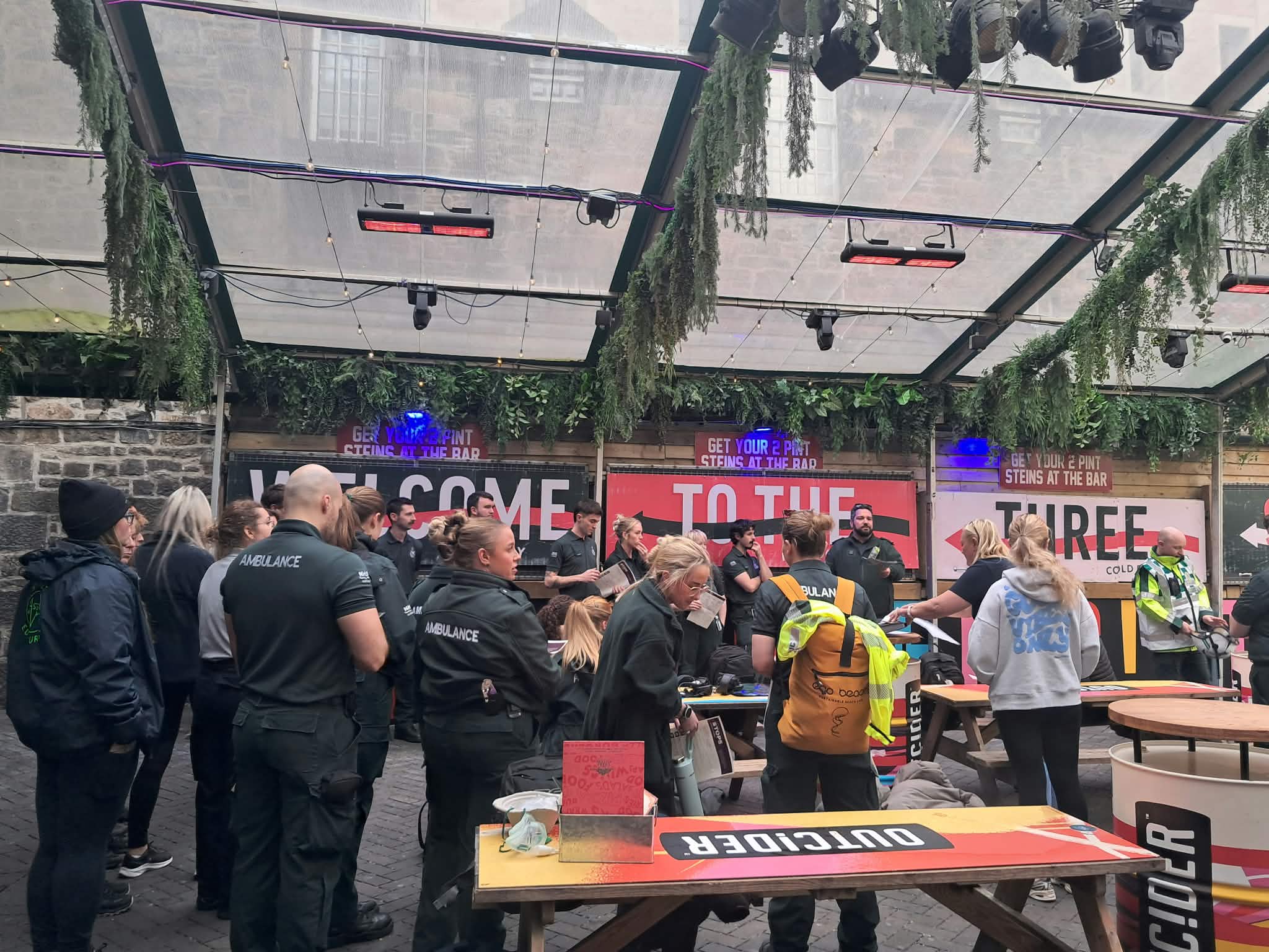 Day shot of SAS staff gathering around in a nightclub learning how to respond to an emergency