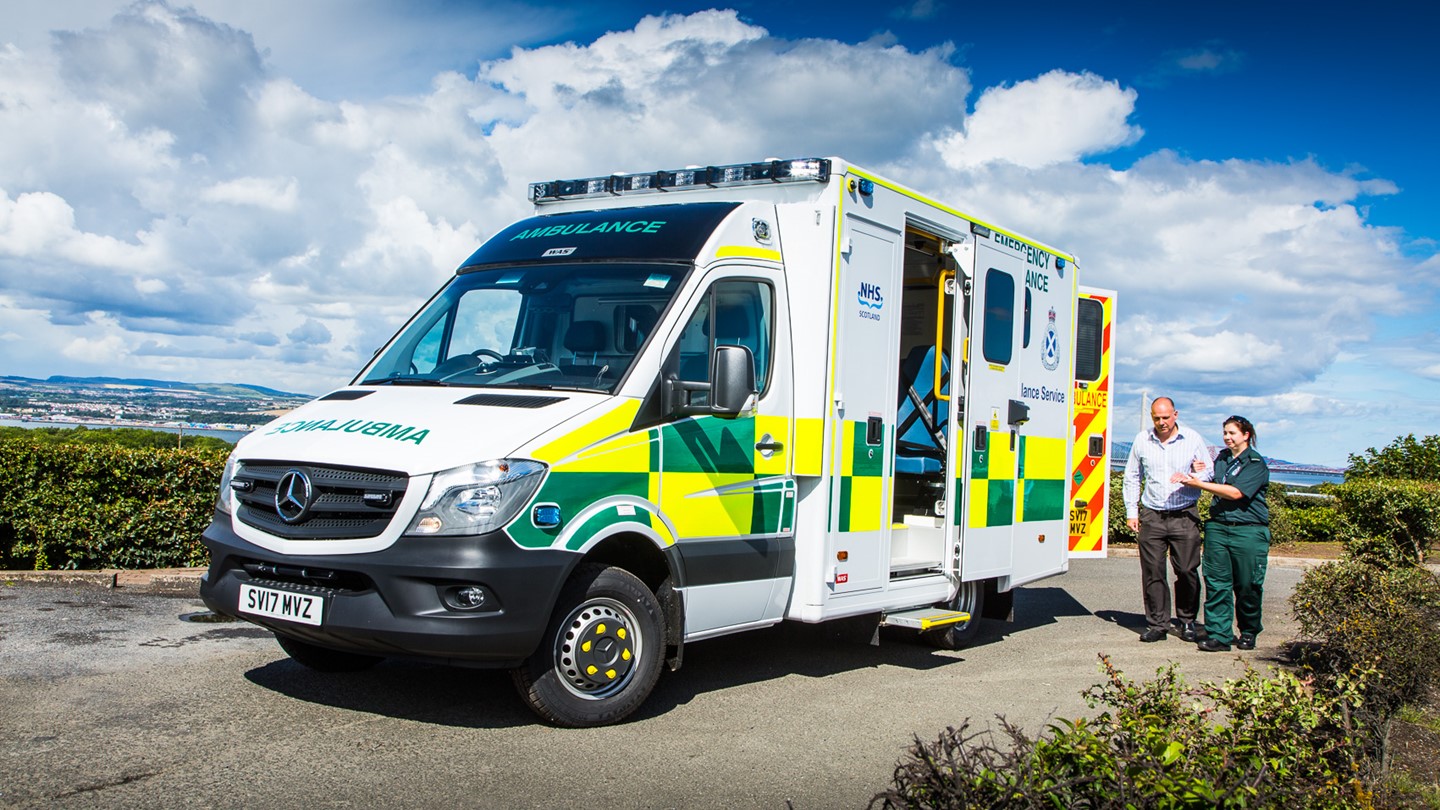 A patient is helped by a Paramedic to an ambulance