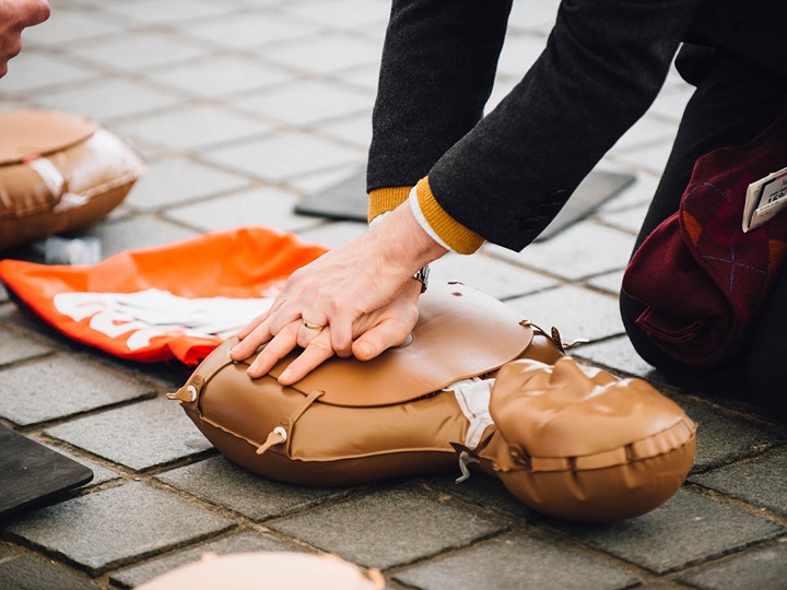 A member of the public practicing CPR on a dummy