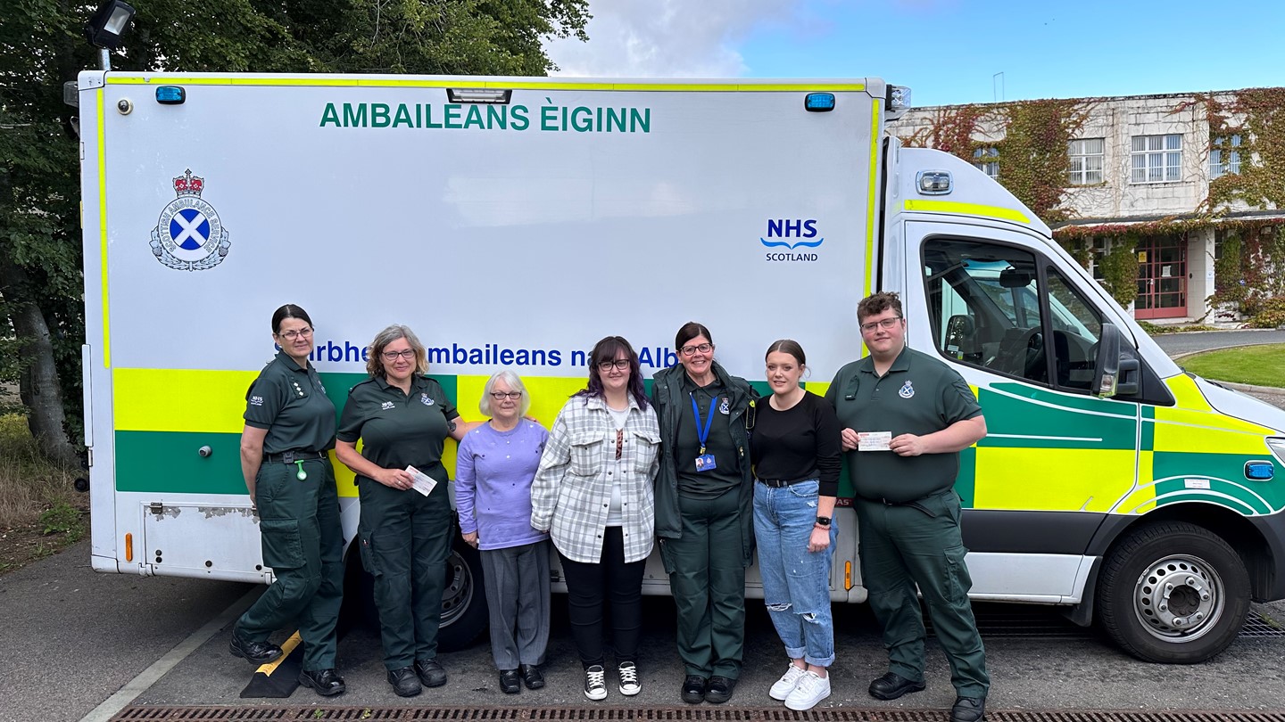 Scottish Ambulance Service staff with family presenting cheque