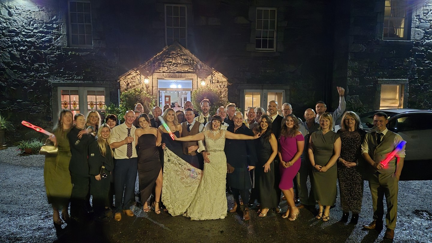 Group picture of everyone celebrating with Sarah's arms open in the middle