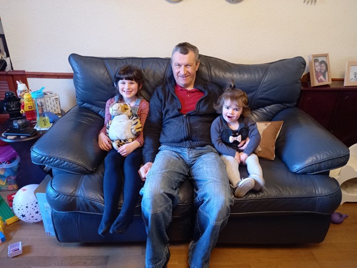 Alan and his family sit on a couch