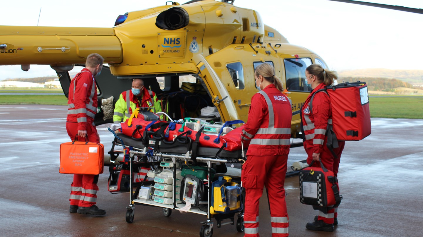 A Paediatric team transfer a child onto an air ambulance helicopter