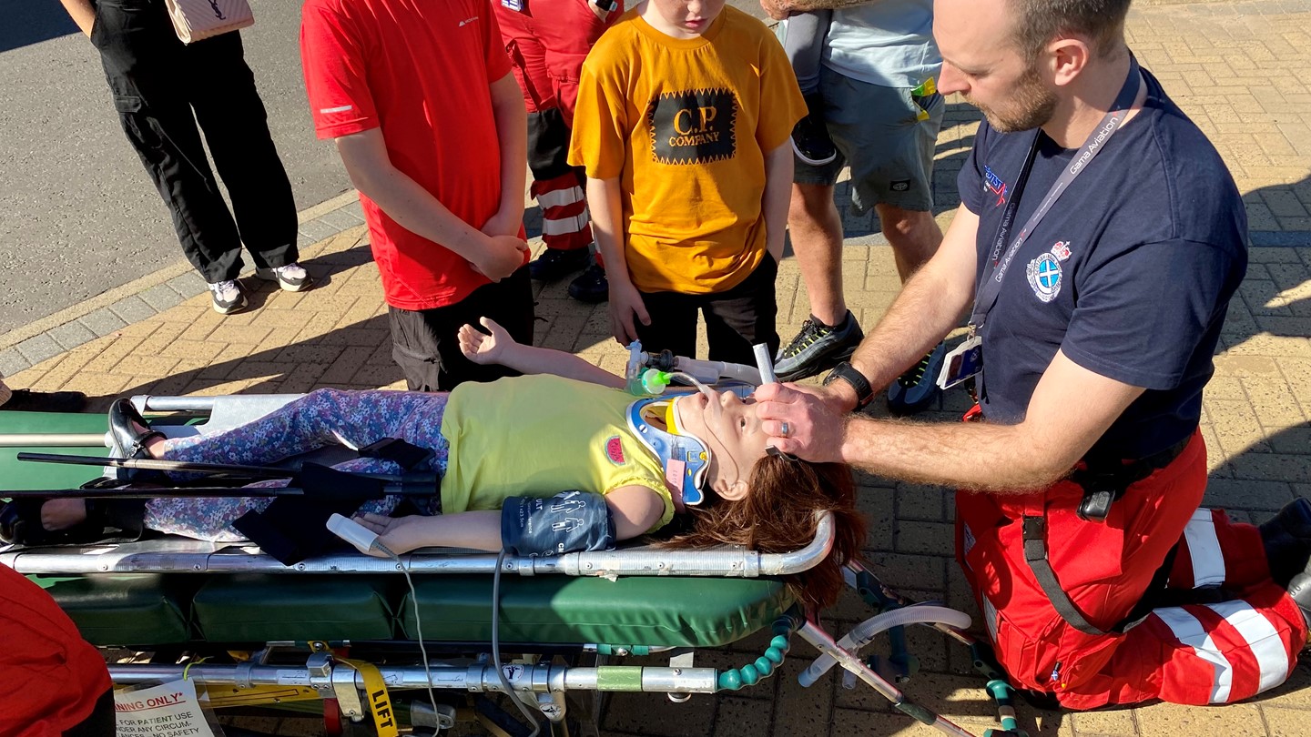 Scotstar paramedic demonstrates medical procedure on female dummy for two young boys.