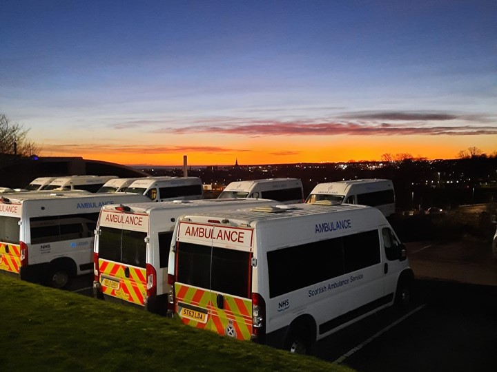 Row of Scheduled Care vehicles under blue sky