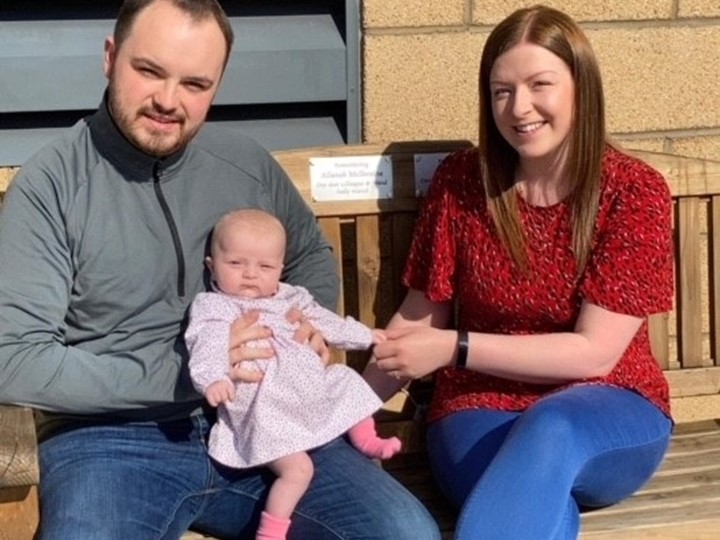 John and Laura, along with their daughter Lana sitting on the bench