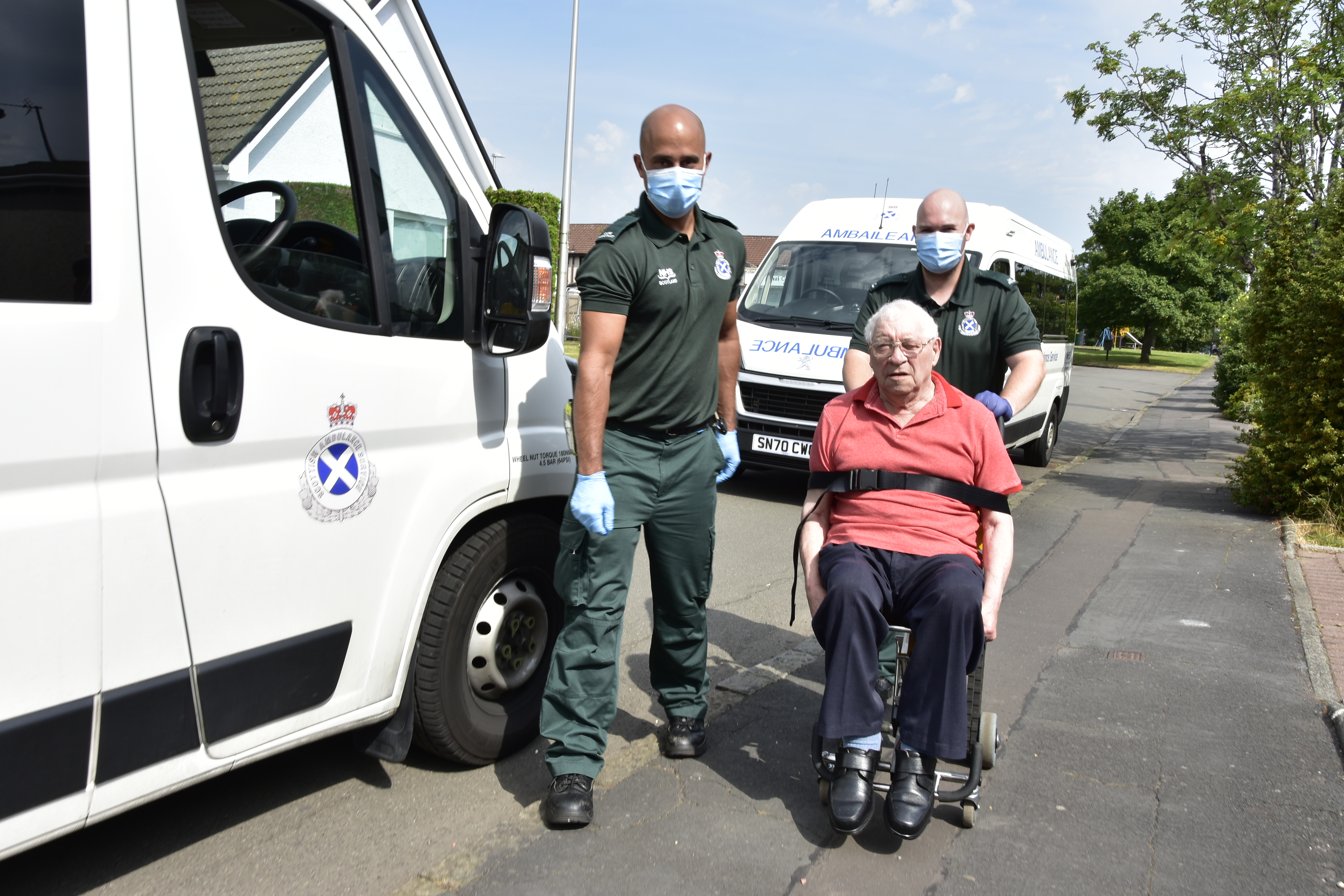 Two Ambulance Care Assistants with a patient next to an ambulance