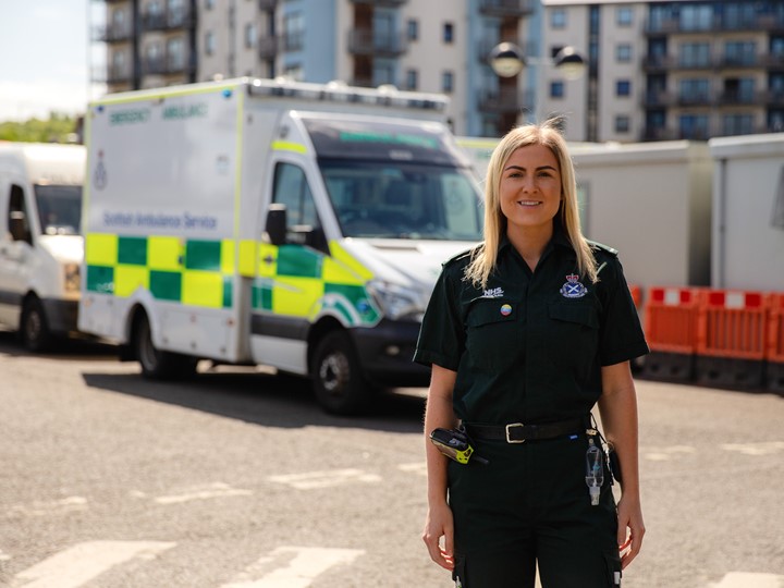 Jenifer Stewart standing in front of an ambulance.