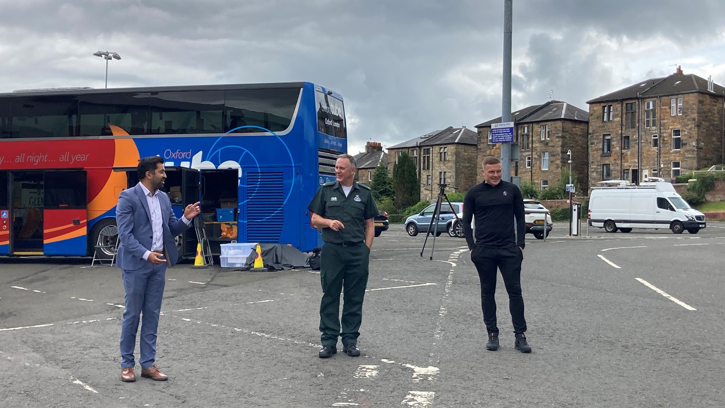 The Cabinet Secretary and staff in front of the vaccine bus