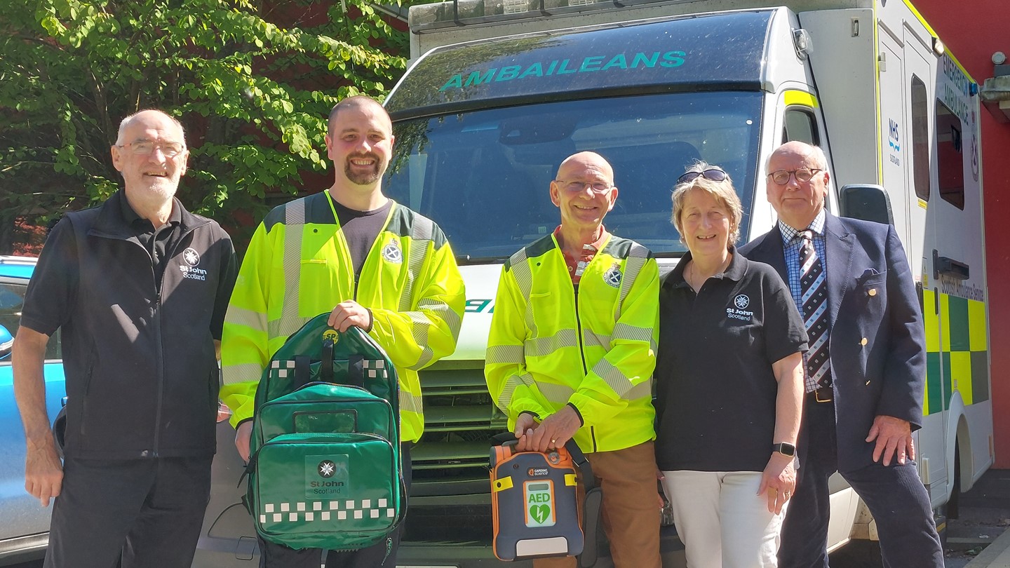 Group of Community First Responders in front of an ambulance