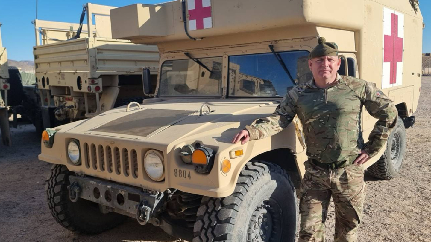 Picture of John Kane in front of an army ambulance