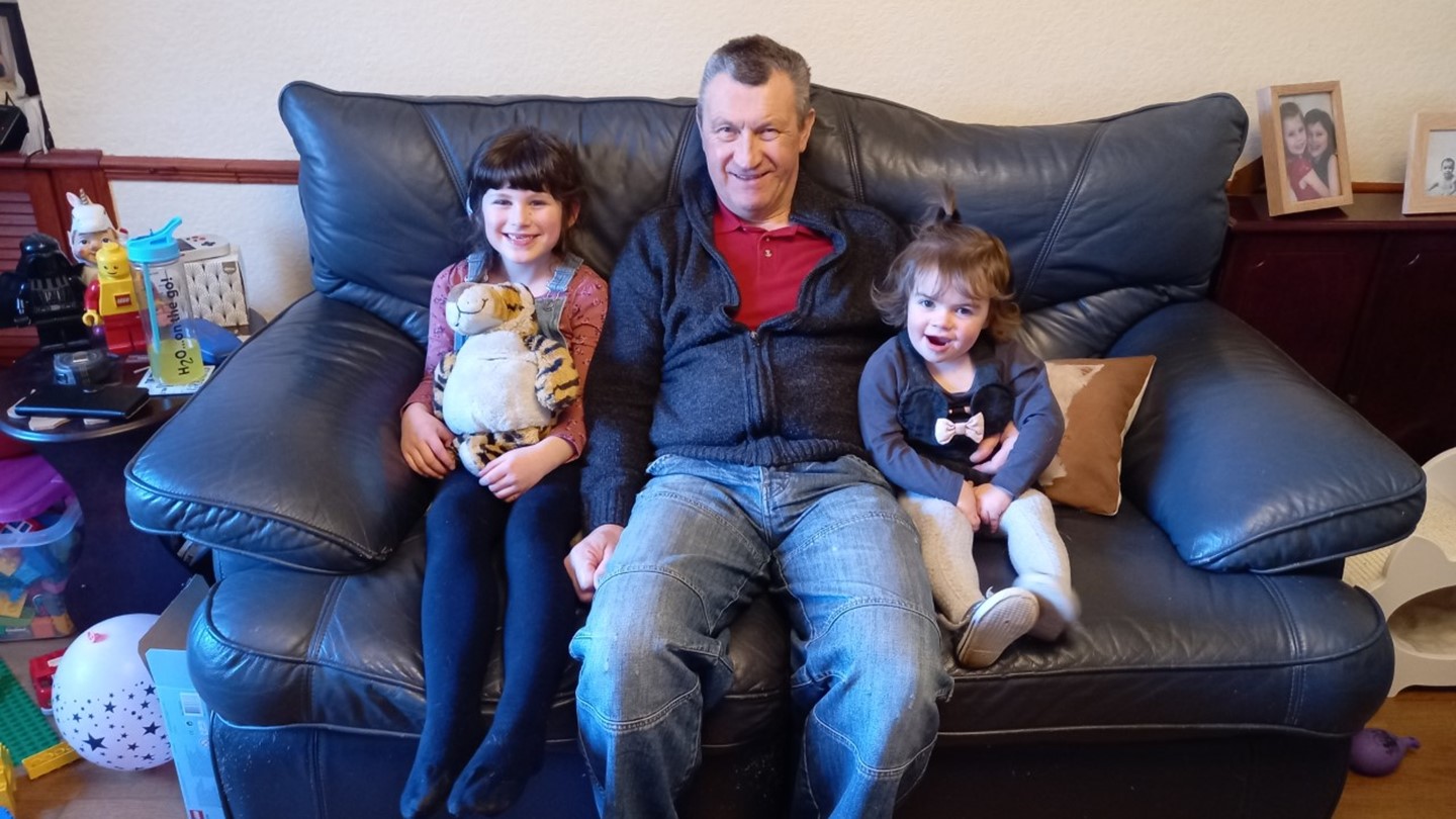 Alan with his kids sitting on a settee