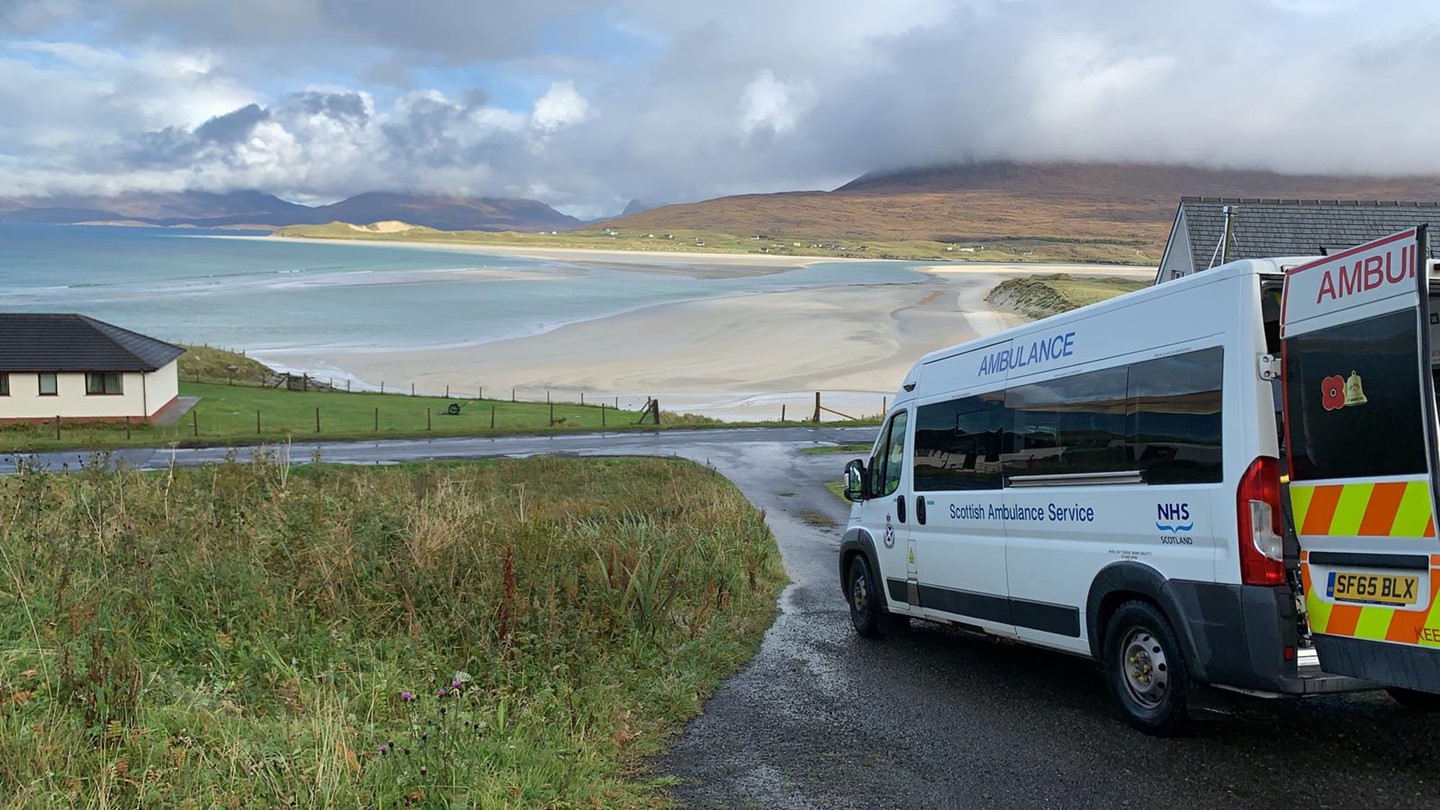 A Scheduled Care Ambulance next to a beach