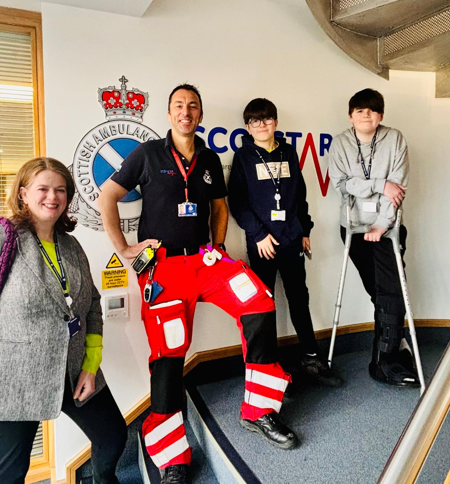 Thomas Bell with staff from the ScotSTAR team in front of a wall with the ScotSTAR logo