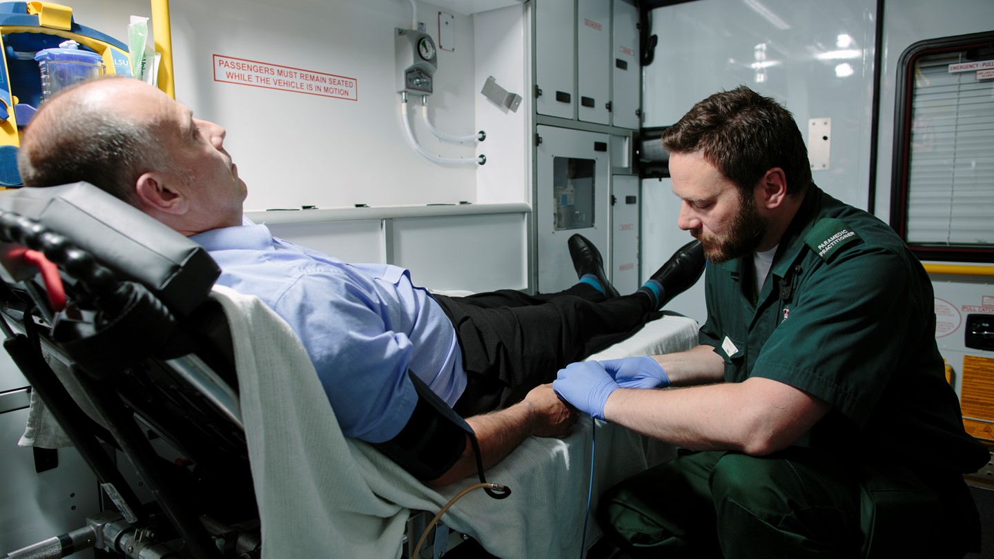 A Paramedic treats a patient in an ambulance