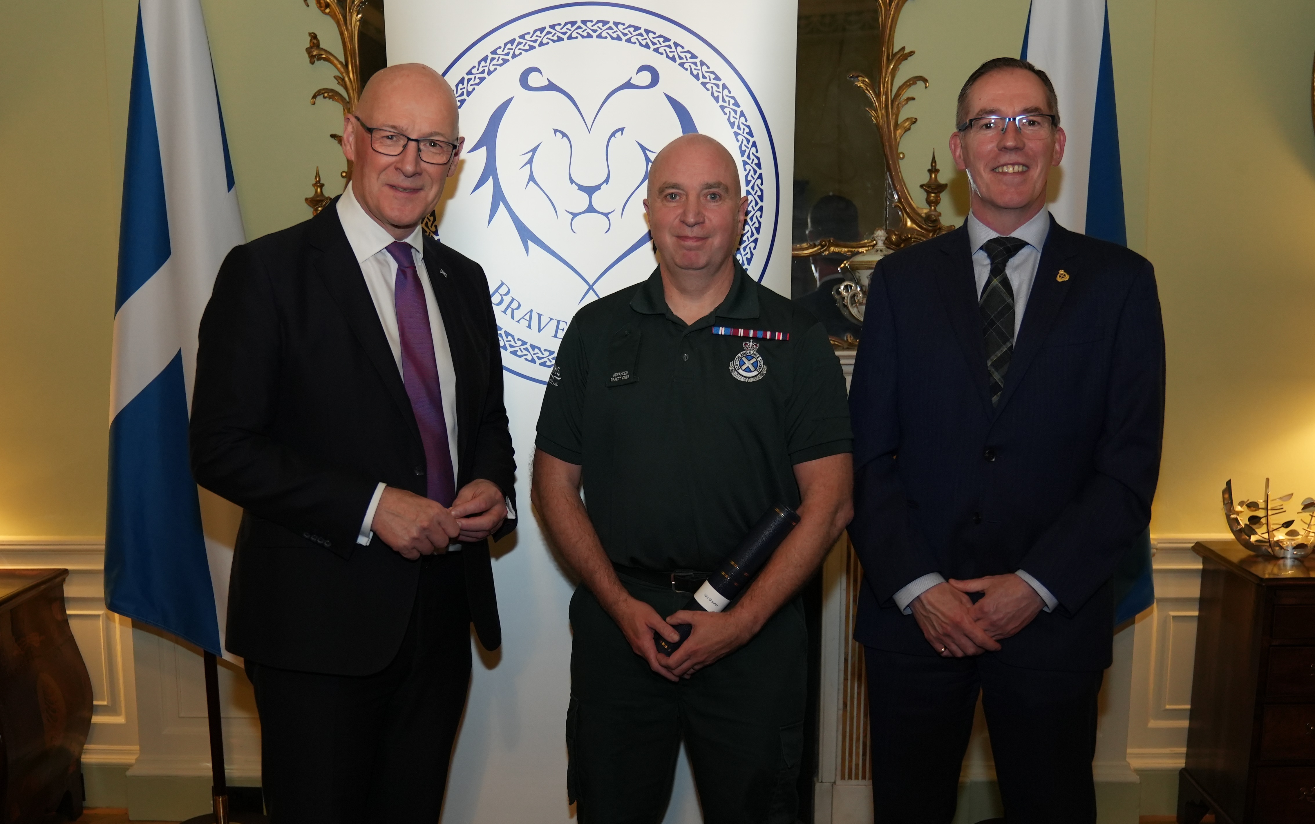 Iain Skinner in SAS green uniform stood with John Swinney, FM, and Michael Dickson, SAS CEO.