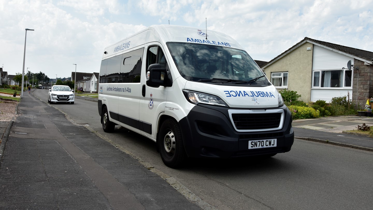 A non-emergency ambulance driving down a street