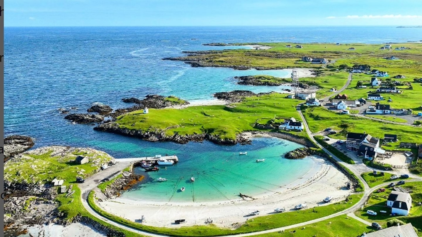Looking down on a beach and the coast line with houses along the coast