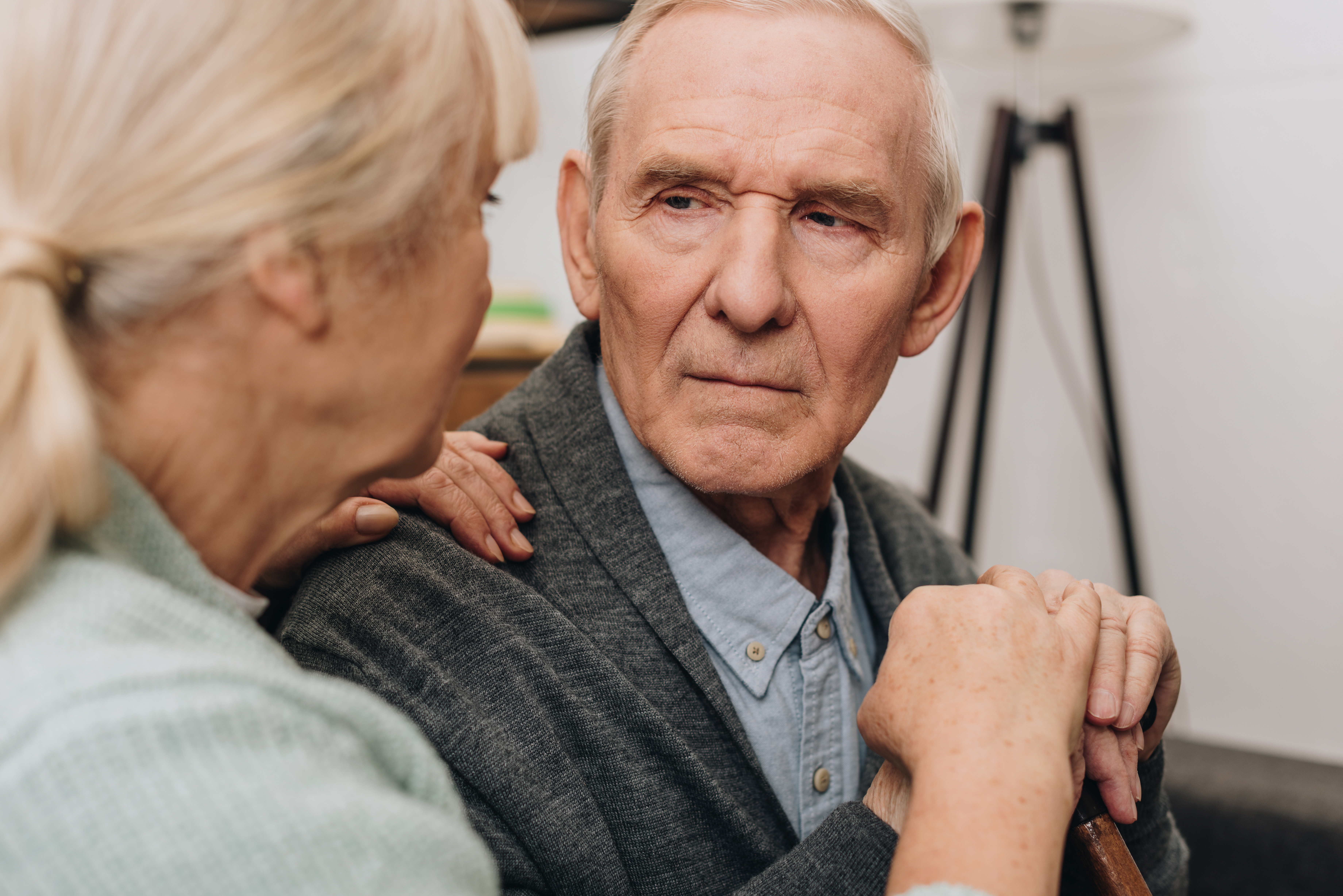 An elderly women looks into the eyes of an elderly man