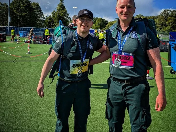 Jack and Dominic stand at the starting line with their full SAS kit and bags on them smiling