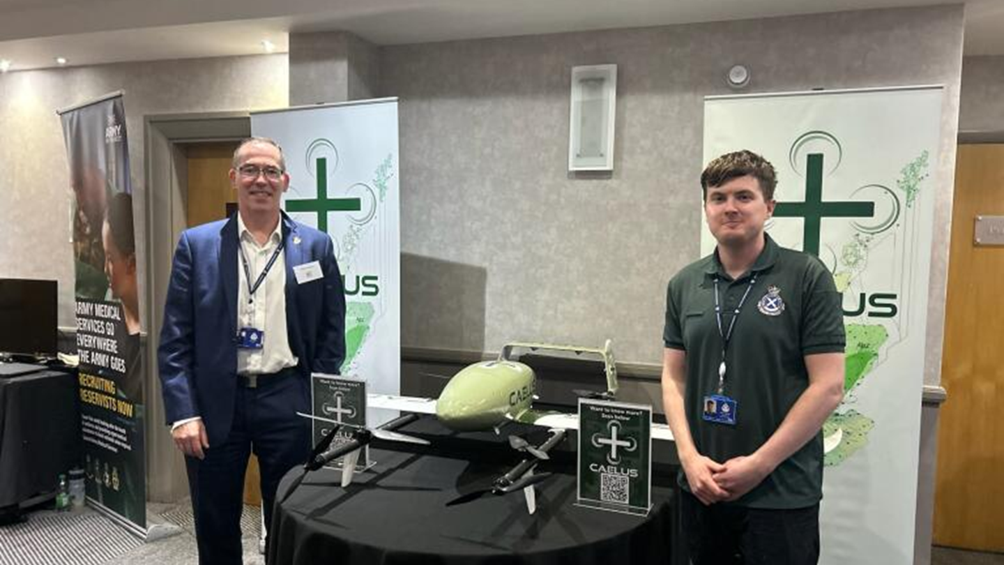 Scottish Ambulance Service Chief Executive Michael Dickson and CAELUS project manager Shaun Marshall stand next to a table with a drone on it