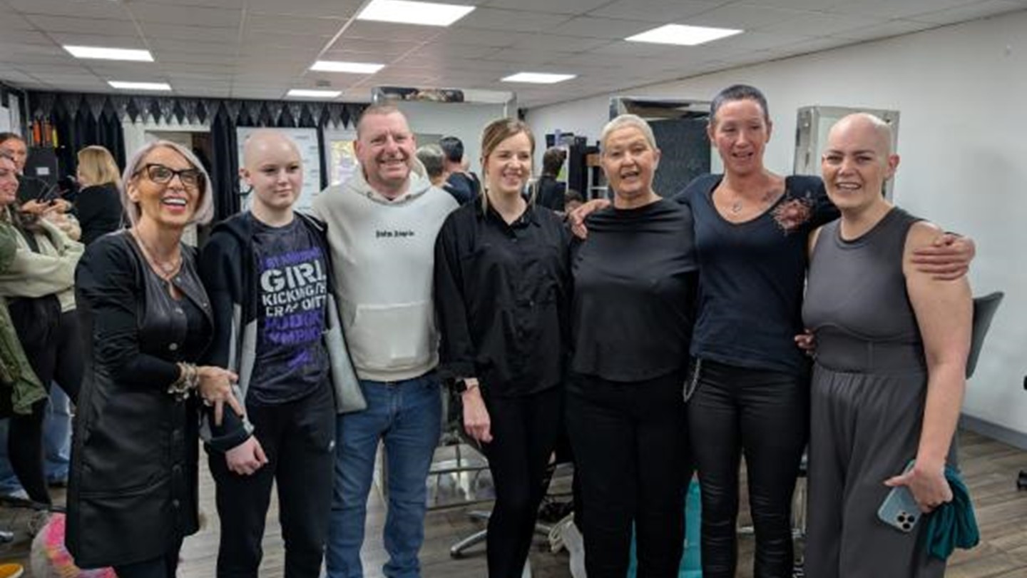 Salon staff, SAS staff and those affected by cancer stand together smiling in a group shot