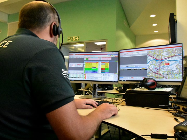 ACC call handler taking a call in front of two screens