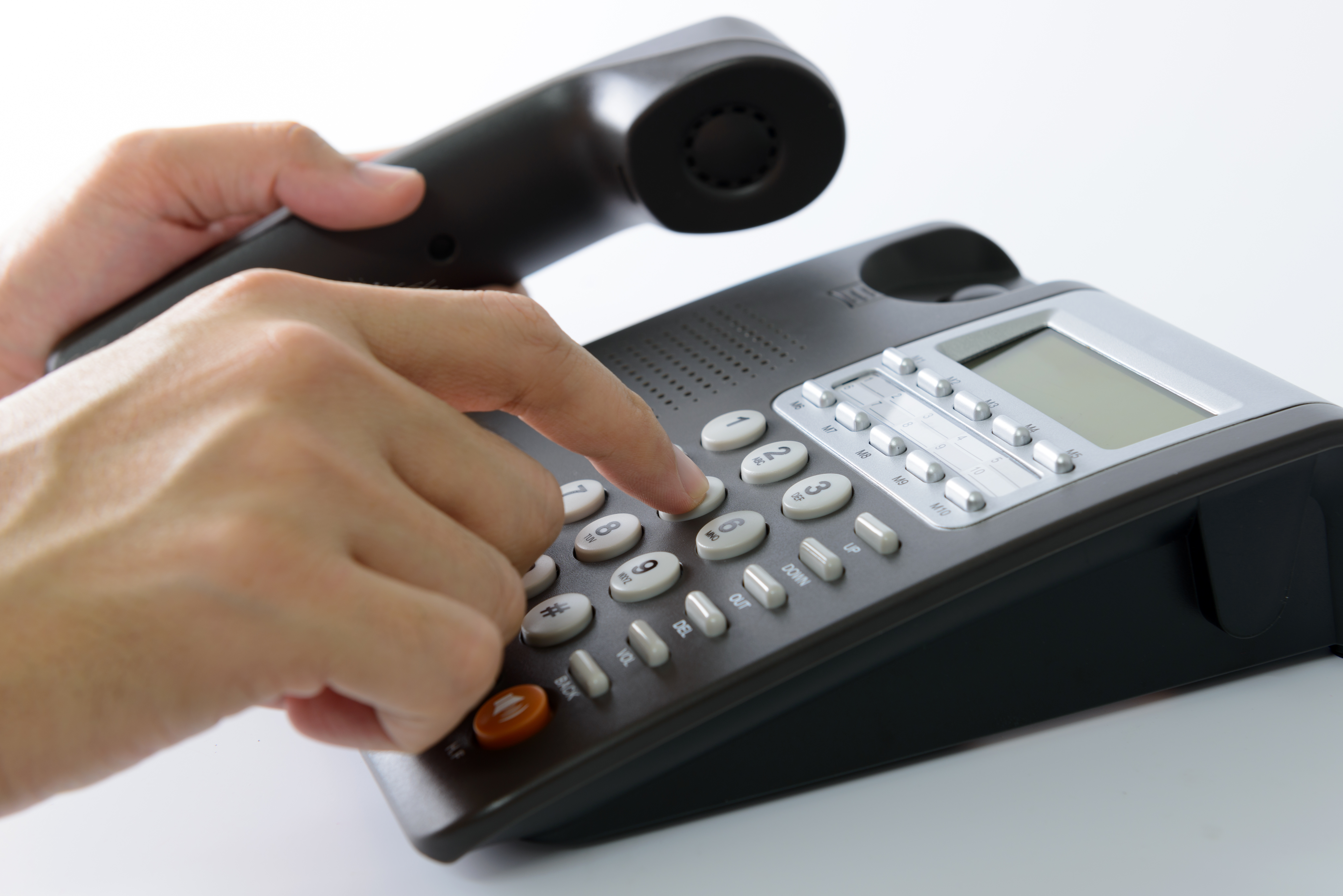 Somebody dialling a number on a landline phone