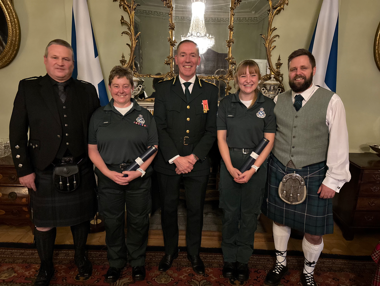 Ailsa and Harriet stand with SAS CEO Michael Dickson proudly with their awards with their partners in kilts at the side