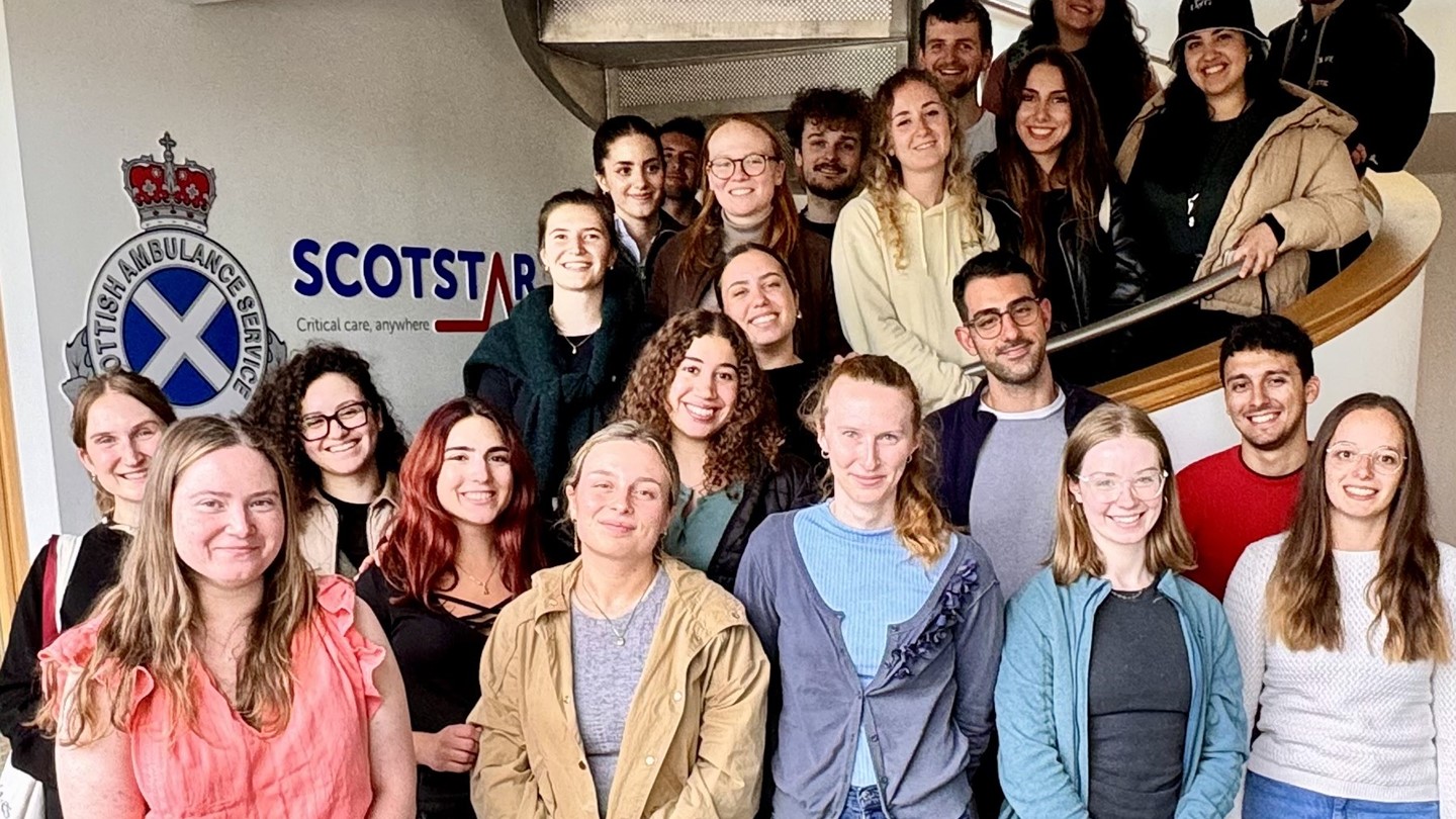Students pose on the stairs with the ScotSTAR sign behind