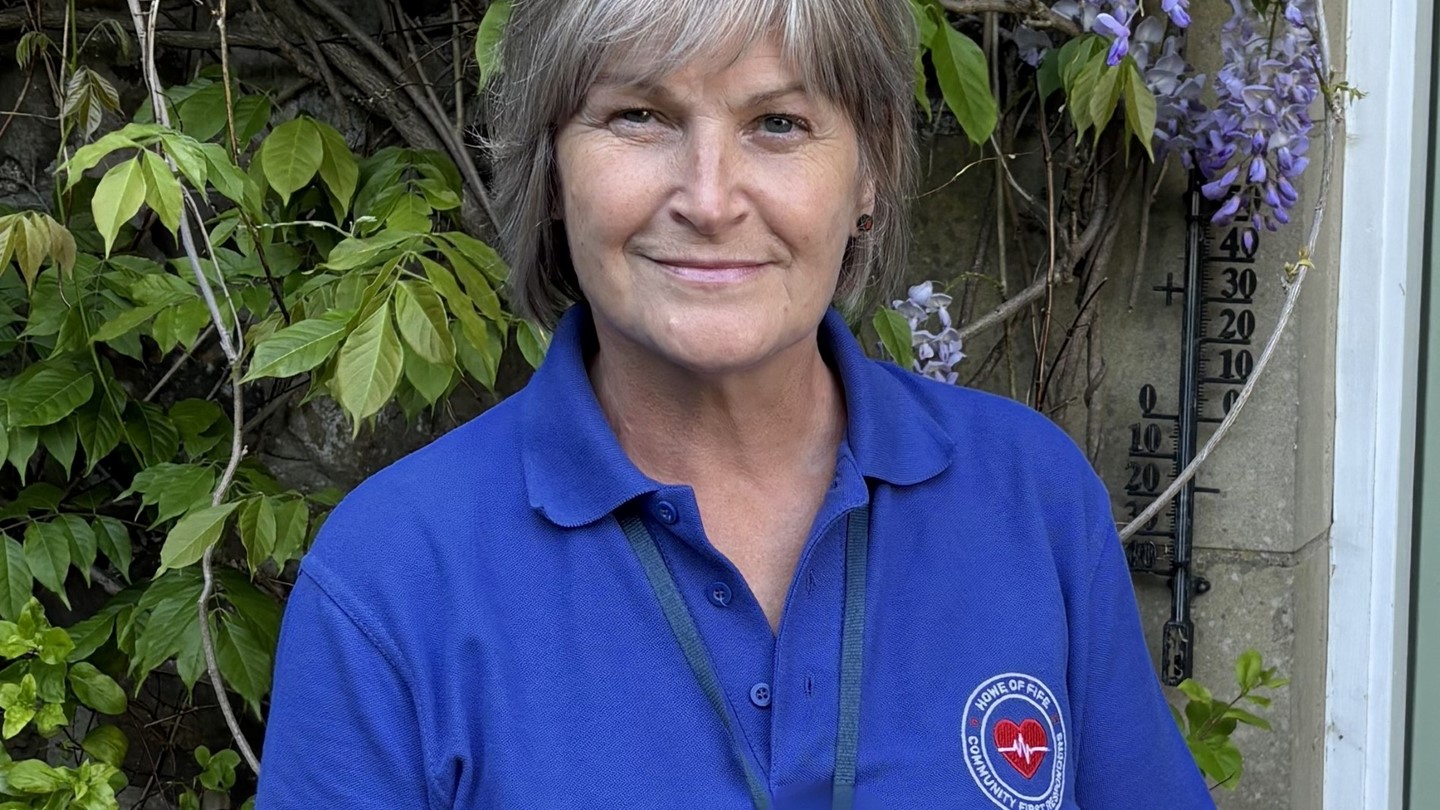Sandra dressed in a blue CFR polo shirt smiling.