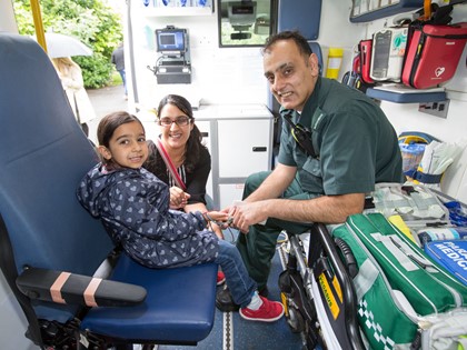 A Paramedic in an ambulance with a young girl and her mother